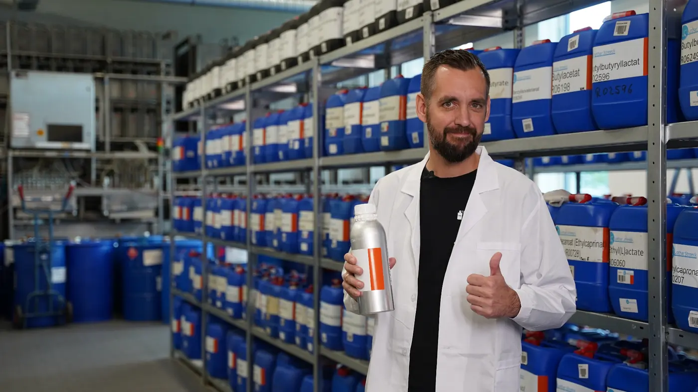 Team member in the raw material warehouse holding an aluminium bottle